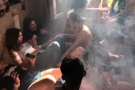 Группа подростков в задымлённой комнате